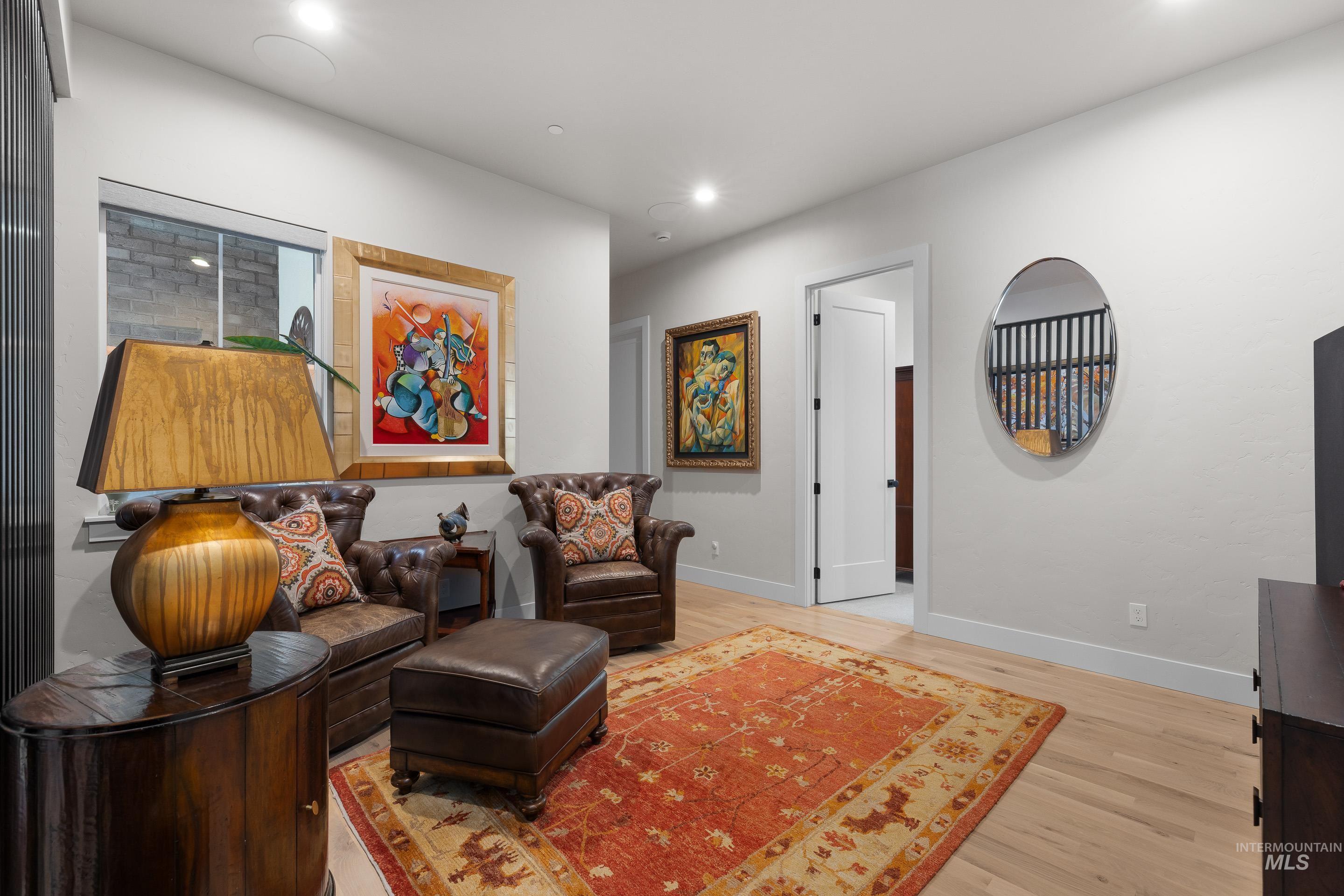 Living area with light wood finished floors and recessed lighting