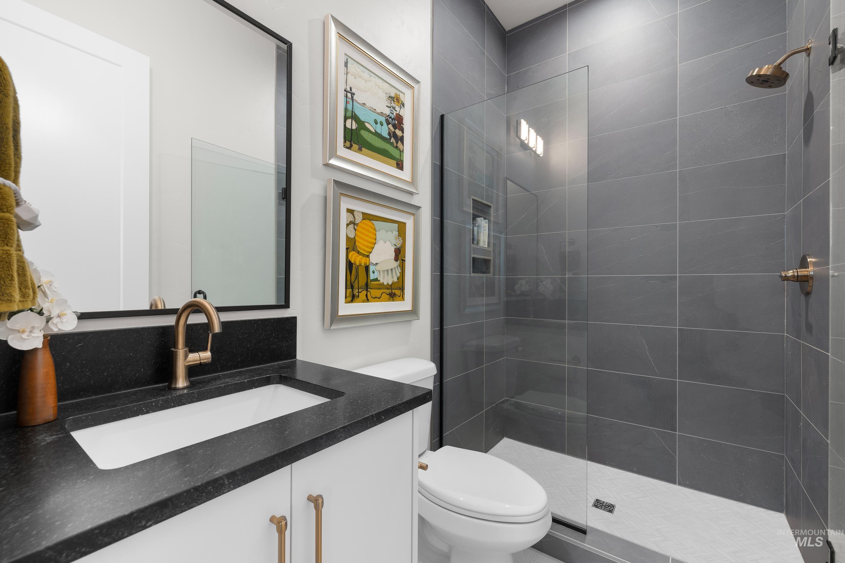 Bathroom featuring vanity and a tile shower