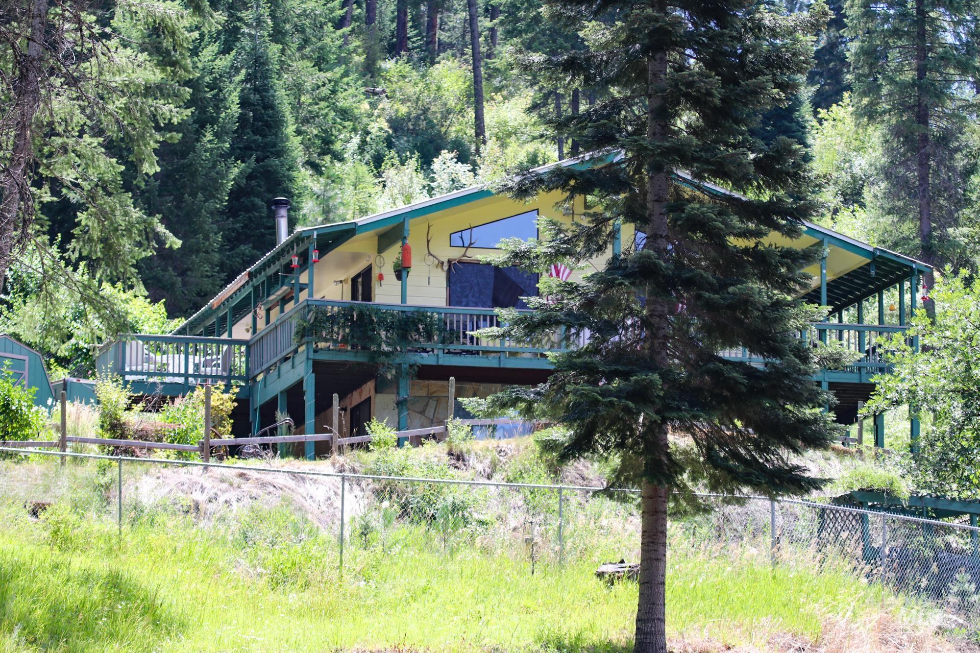 Rear view of property featuring a view of trees and a wooden deck