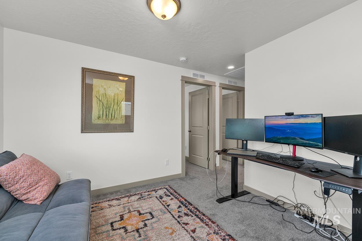 Office with light colored carpet, a textured ceiling, and recessed lighting