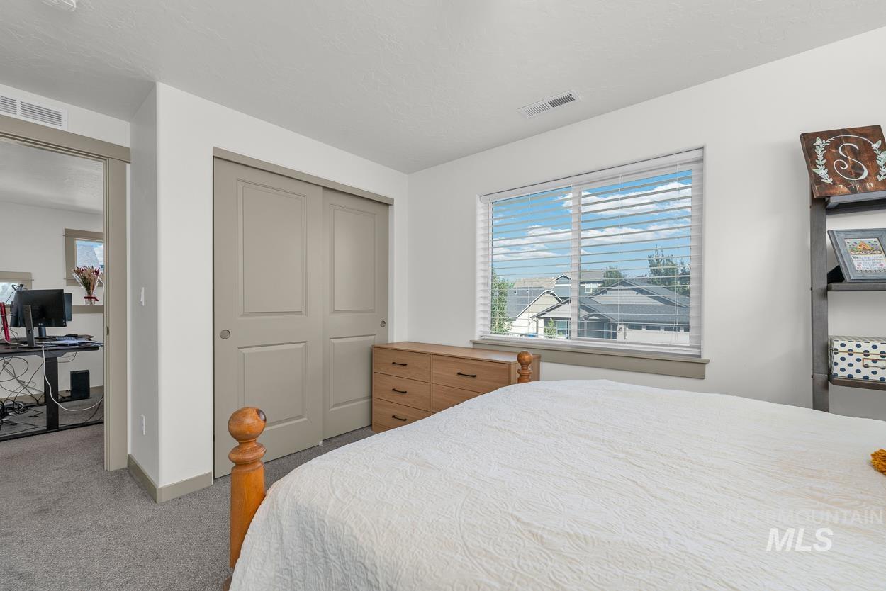 Carpeted bedroom featuring a closet and an office area