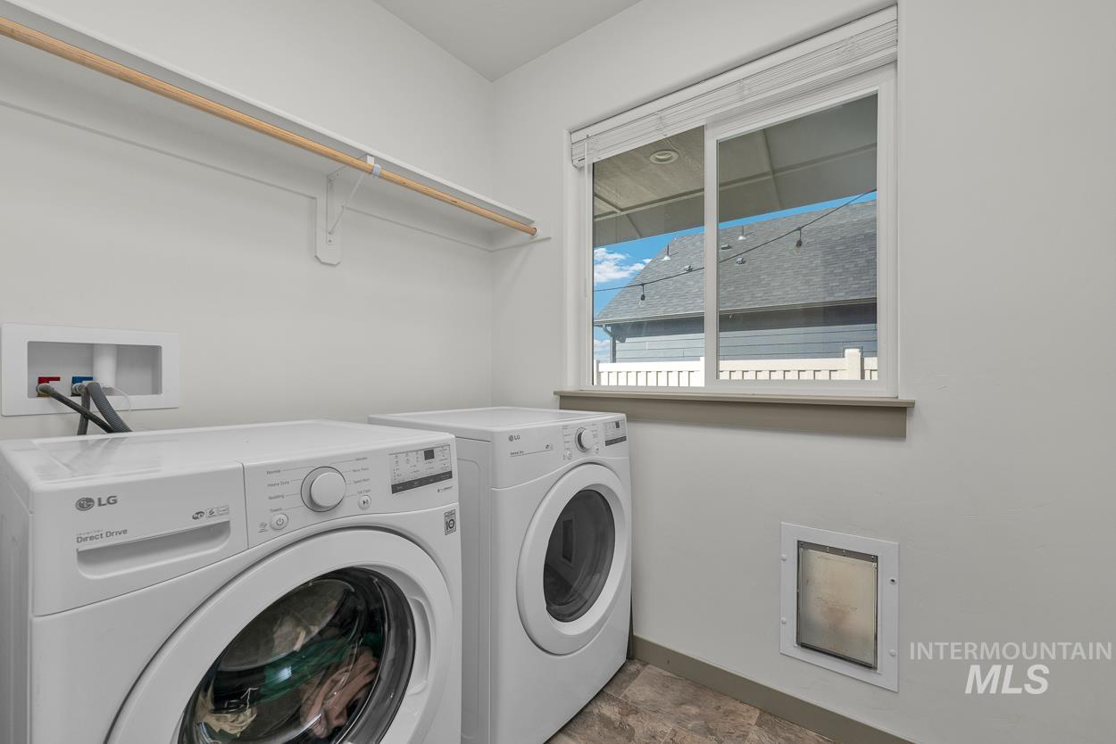 Laundry room featuring washing machine and dryer and baseboards