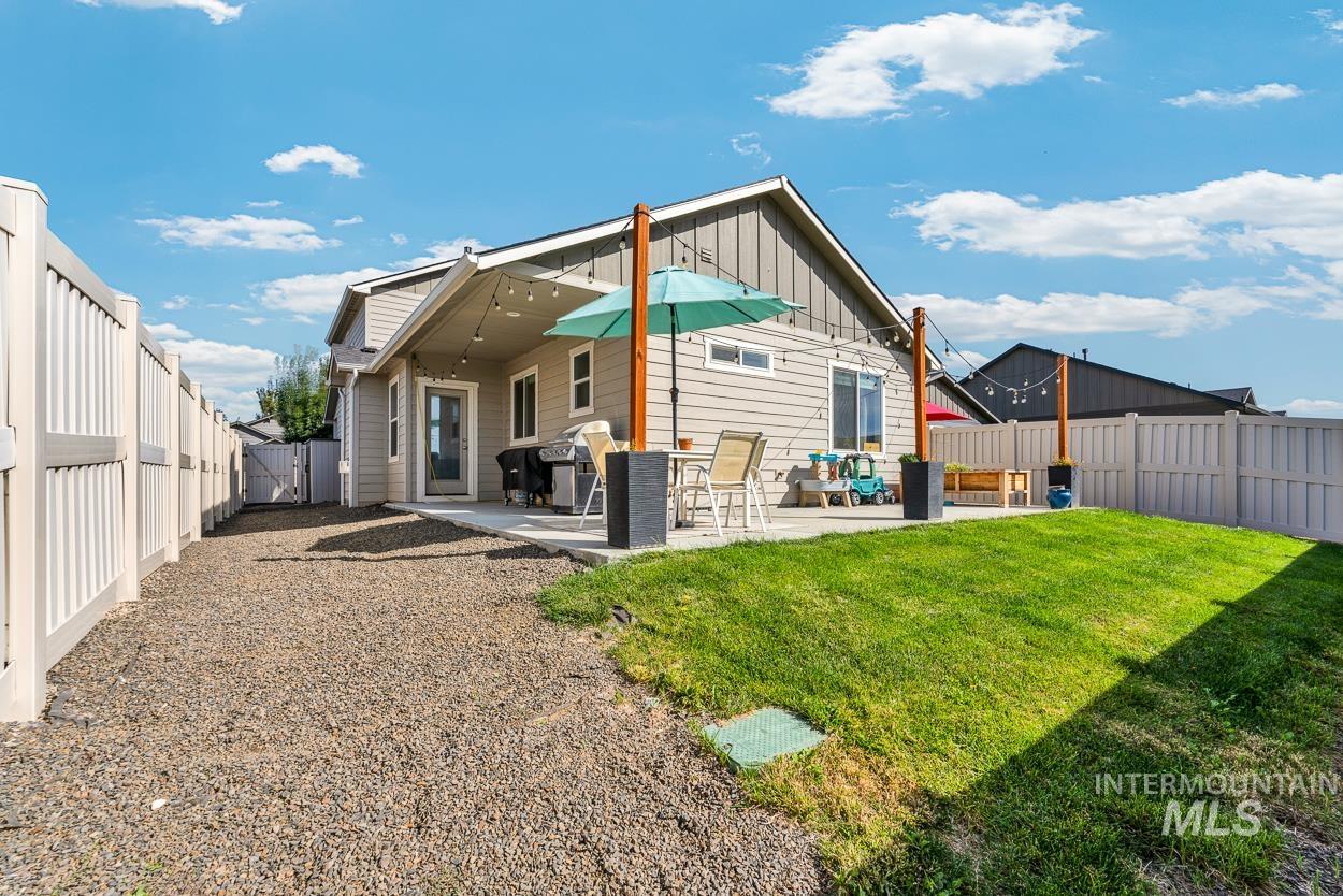 Back of house with a patio area, a fenced backyard, and board and batten siding