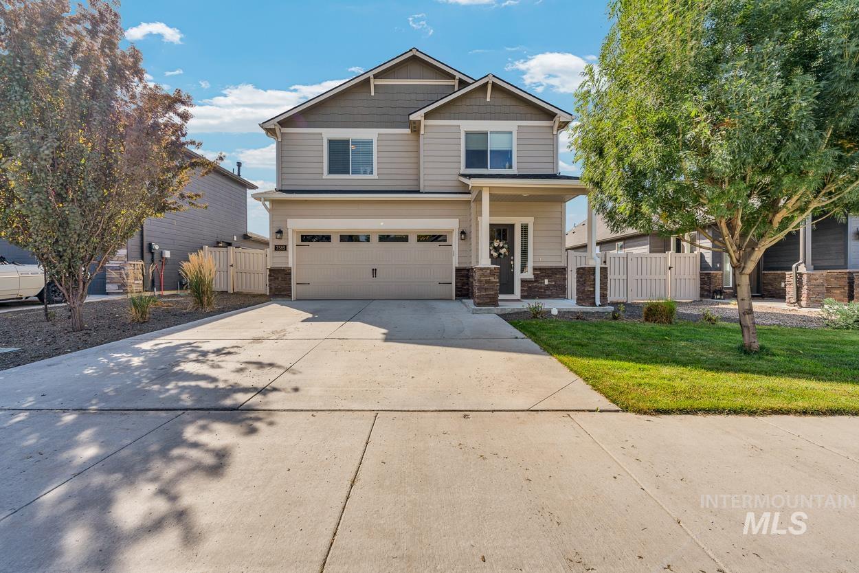 Craftsman-style home with a gate, driveway, stone siding, an attached garage, and a porch