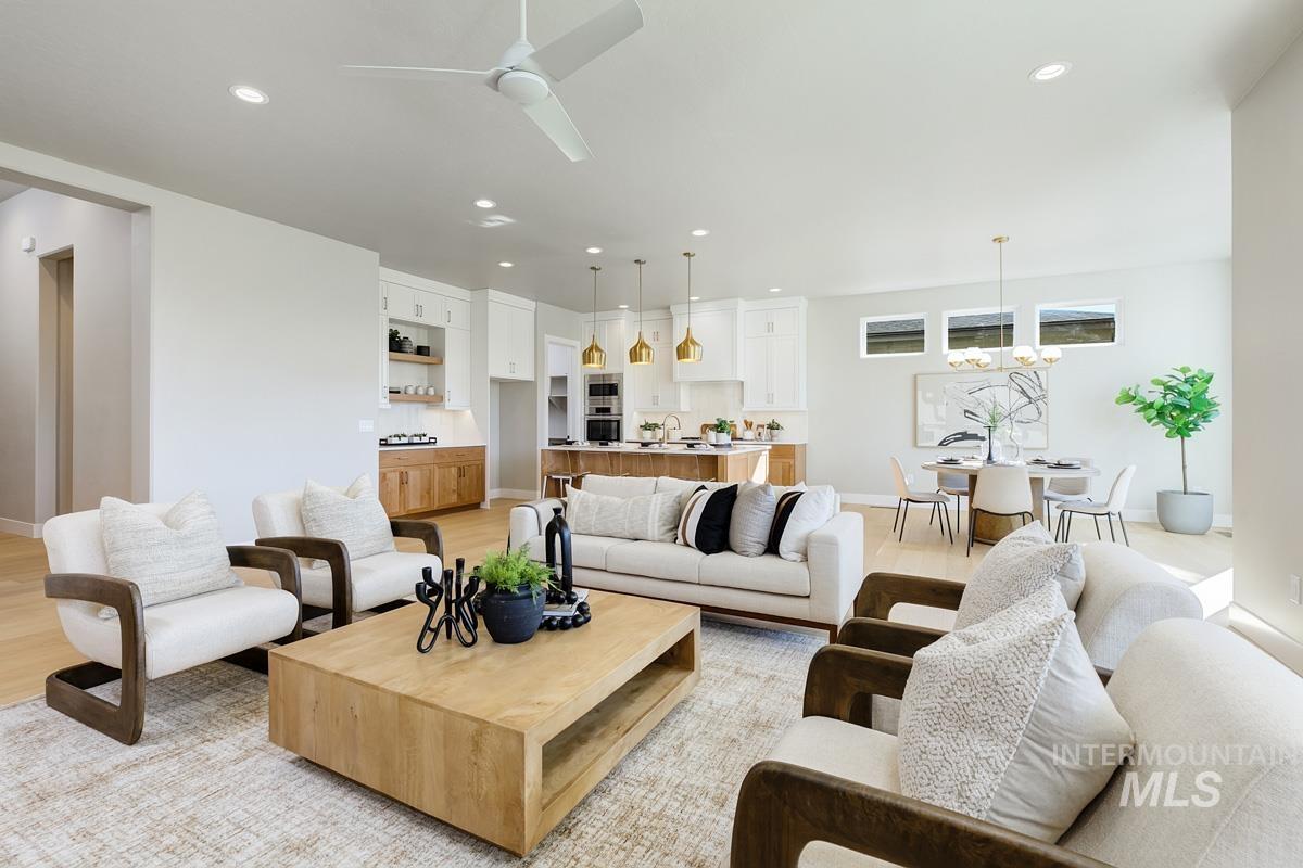 Living room featuring recessed lighting, ceiling fan, light wood-style flooring, and a chandelier