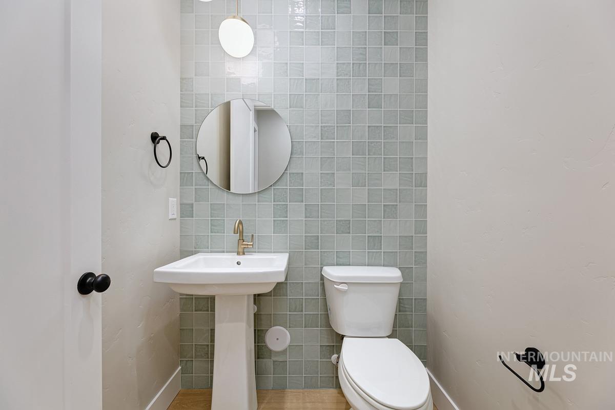 Bathroom featuring tile walls and toilet