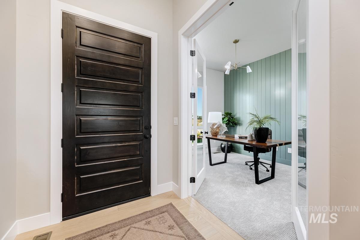 Entryway featuring a desk, a chandelier, and wood finished floors