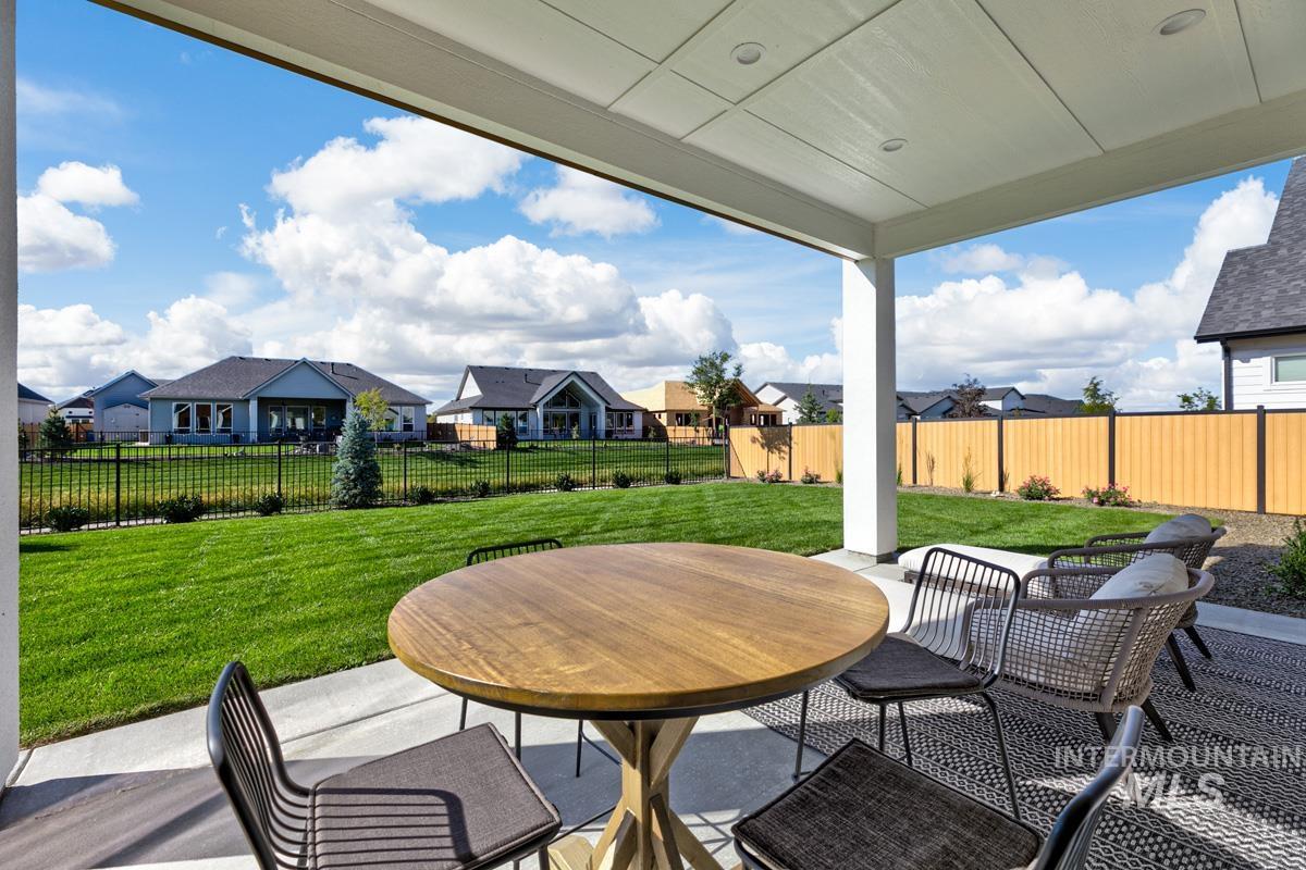 Fenced backyard featuring a patio area, a residential view, and outdoor dining space