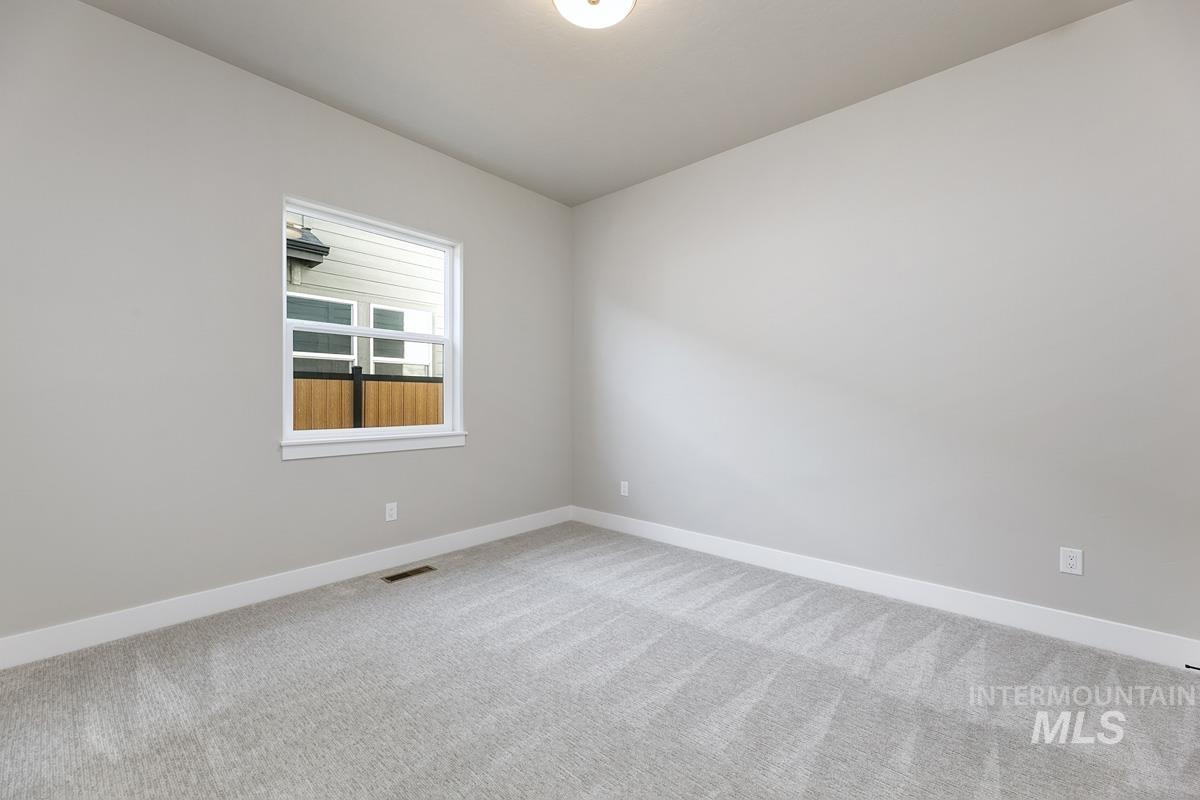 Empty room featuring carpet flooring and baseboards
