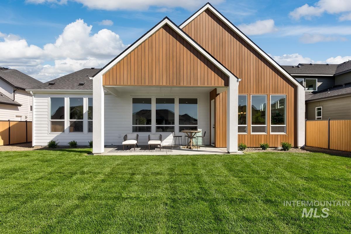 Rear view of property with a patio area and board and batten siding