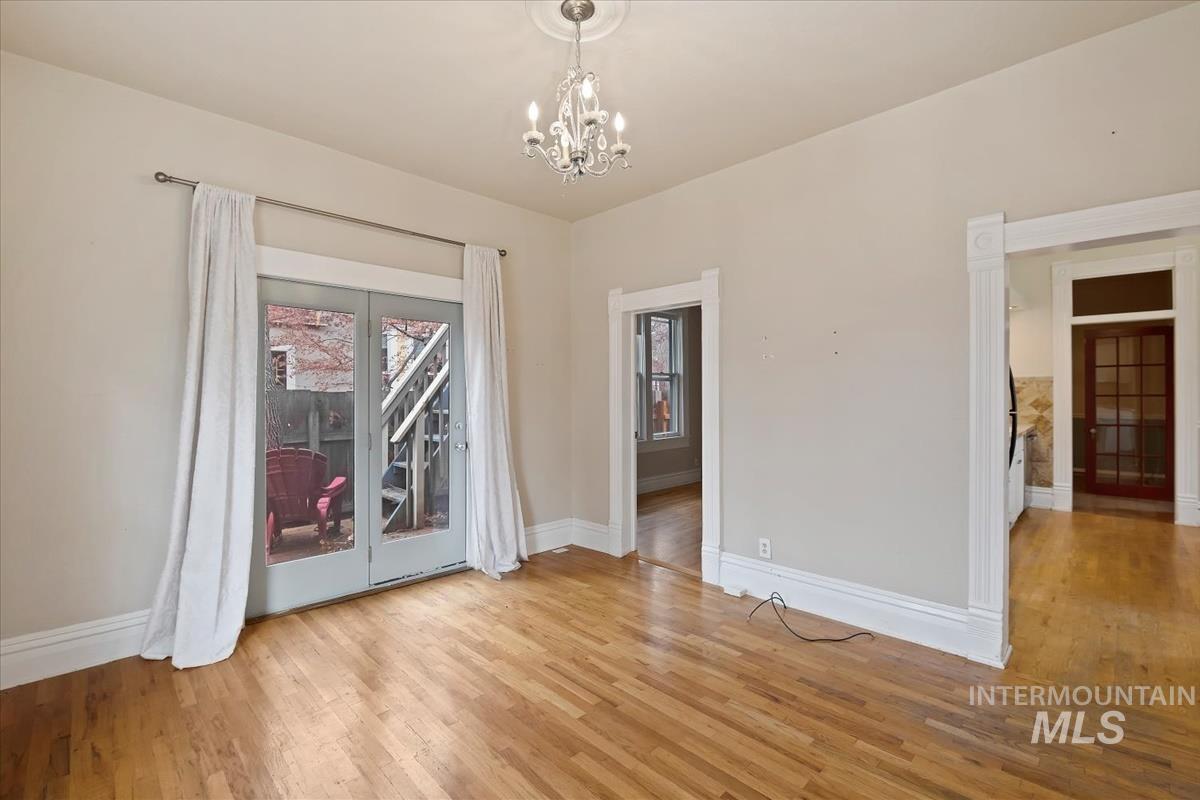 Spare room featuring light wood-style flooring and a chandelier