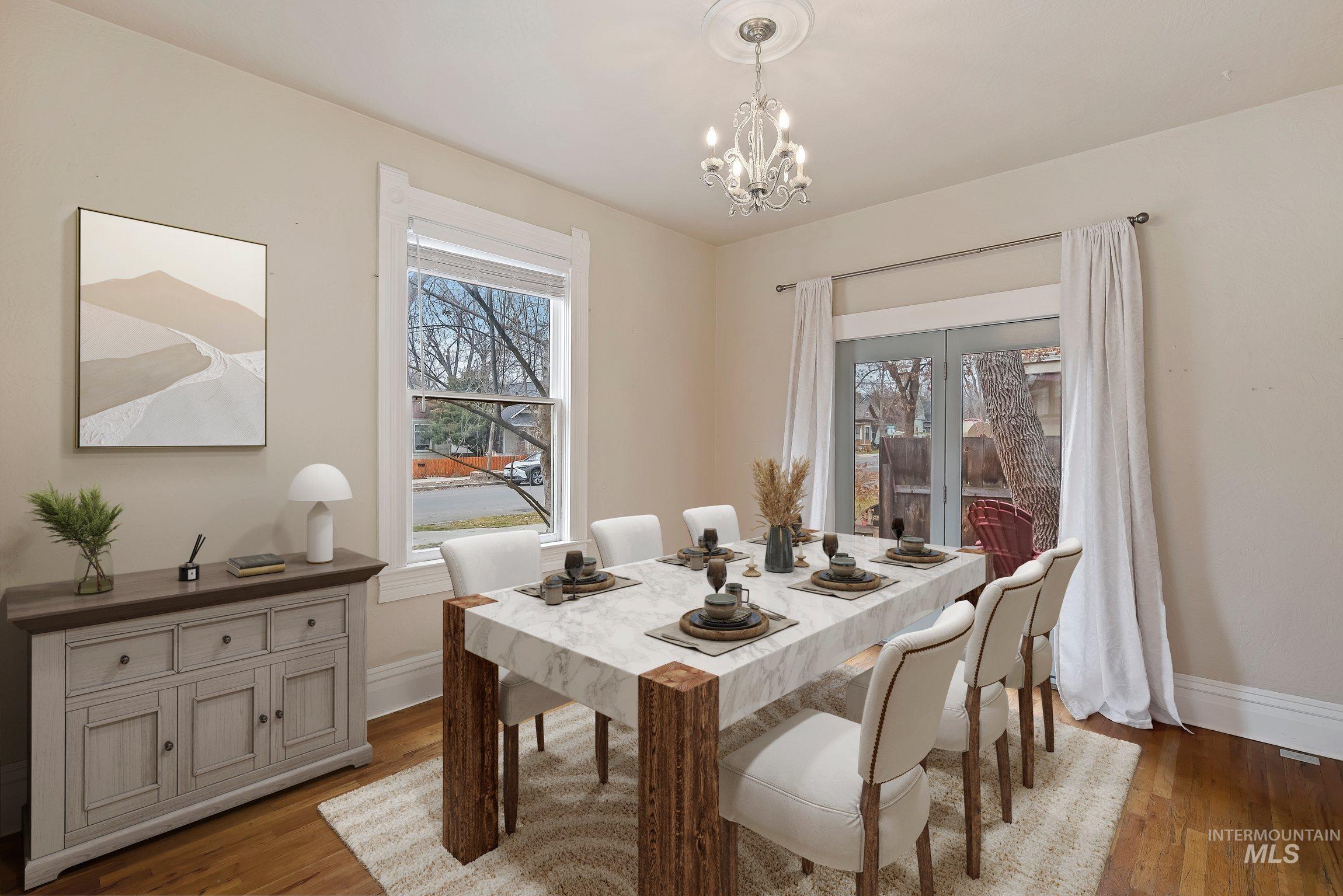 Dining area with hardwood / wood-style floors and a chandelier