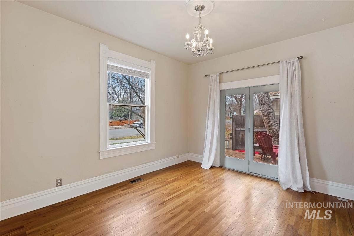 Spare room with hardwood / wood-style flooring and a chandelier