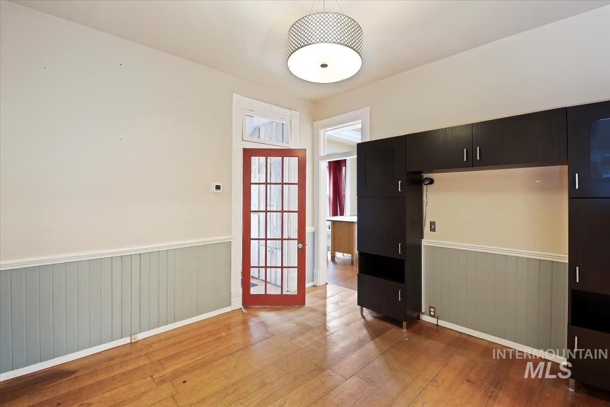 Entryway with hardwood / wood-style floors and a wainscoted wall
