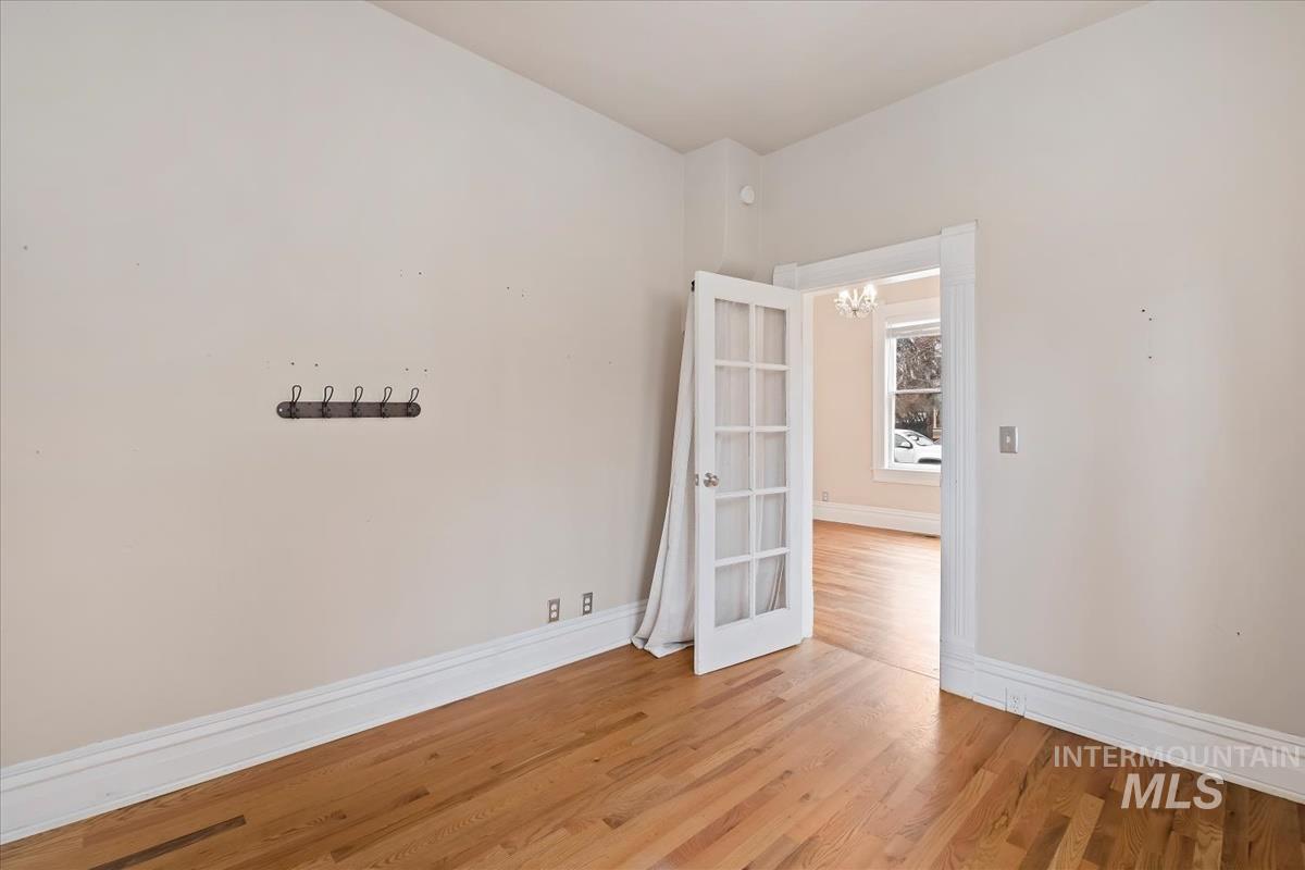 Unfurnished room featuring light wood-type flooring and a chandelier