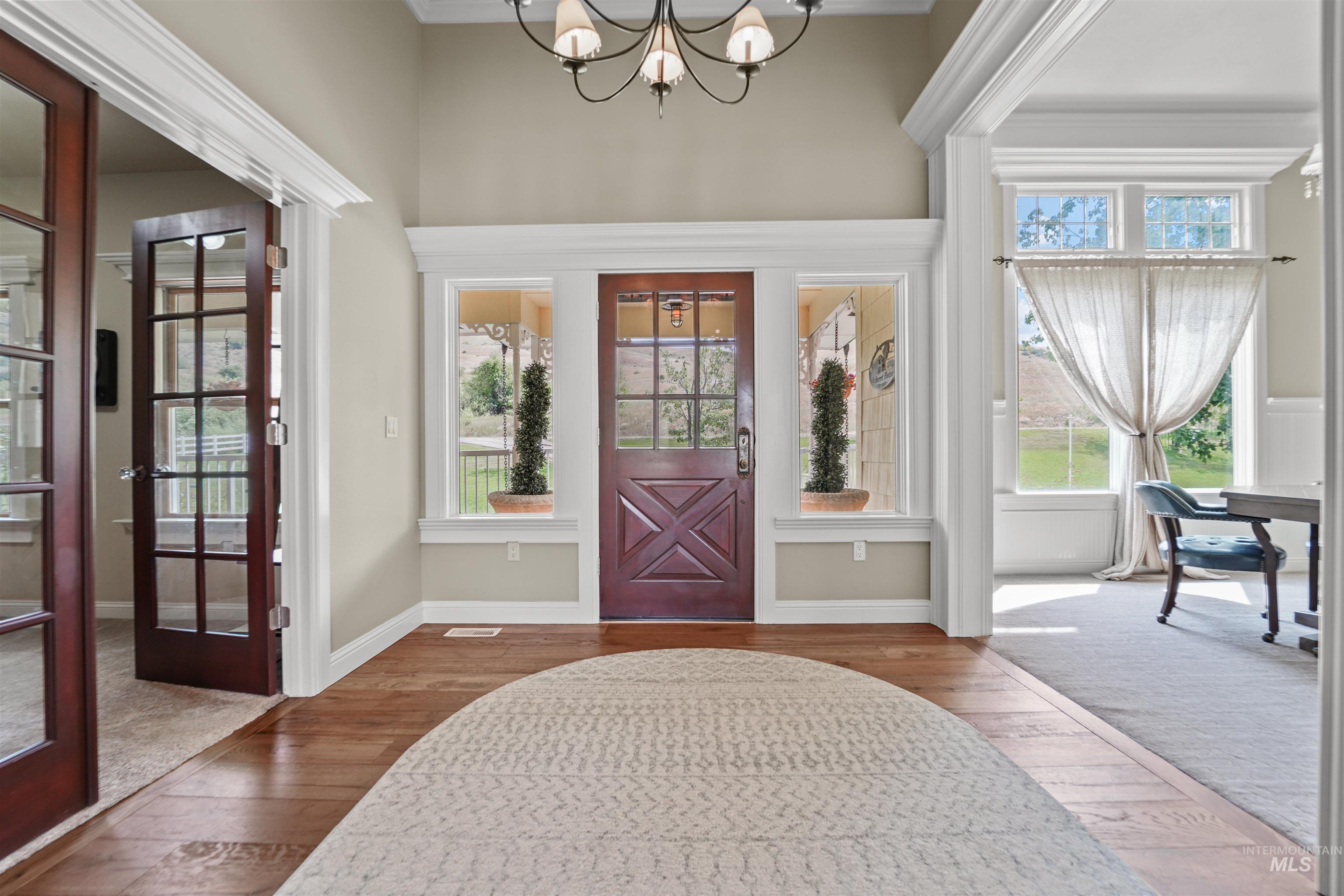 Foyer with hardwood / wood-style flooring and a chandelier
