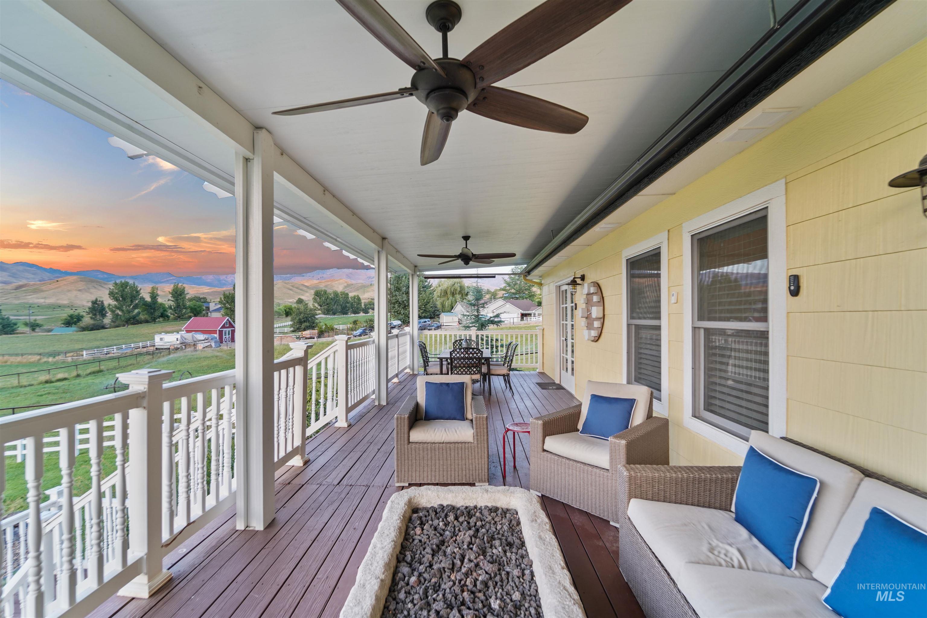 Deck at dusk featuring a mountain view, ceiling fan, and an outdoor living space