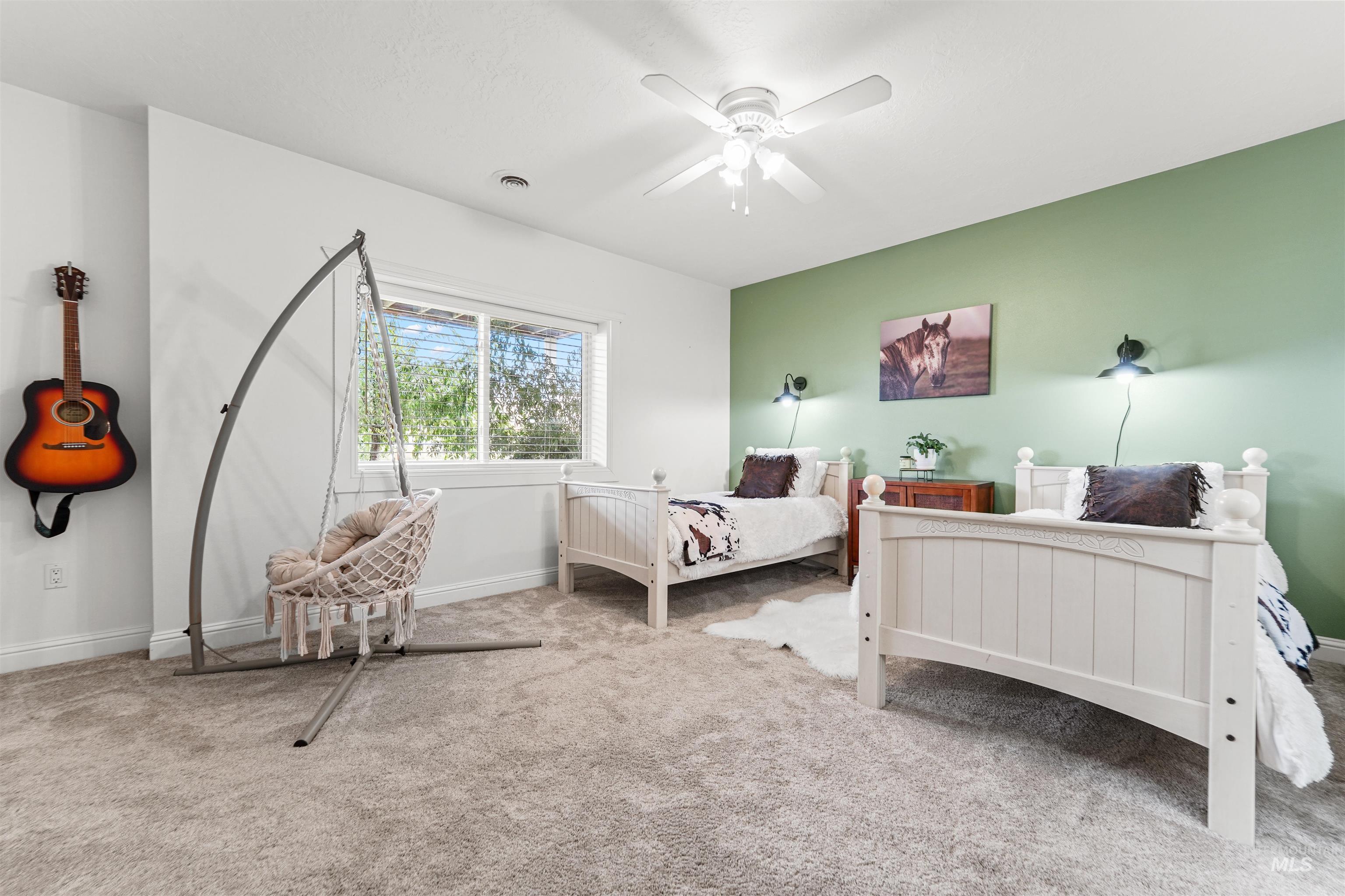 Carpeted bedroom featuring baseboards and ceiling fan