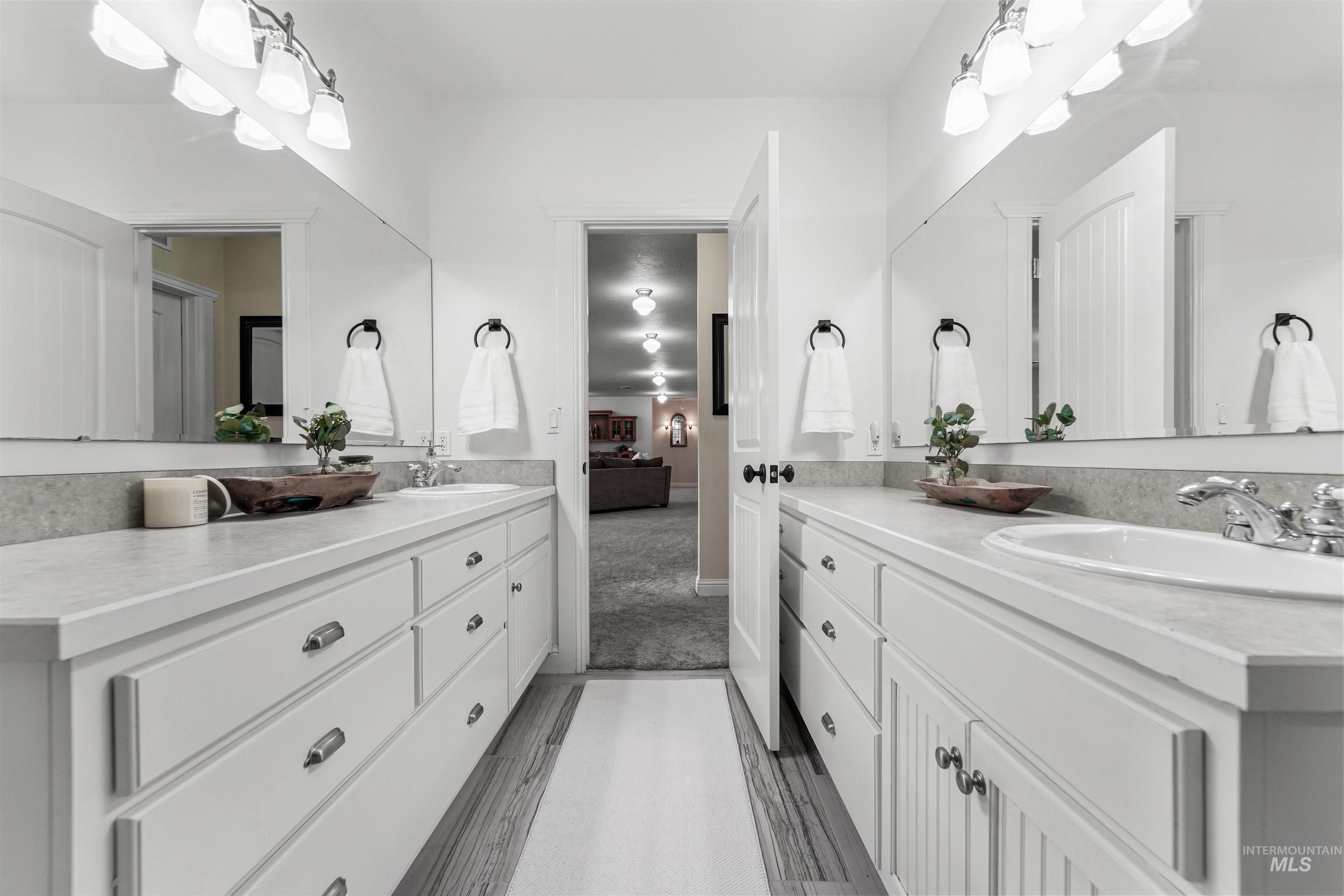 Bathroom featuring two vanities and ensuite bath