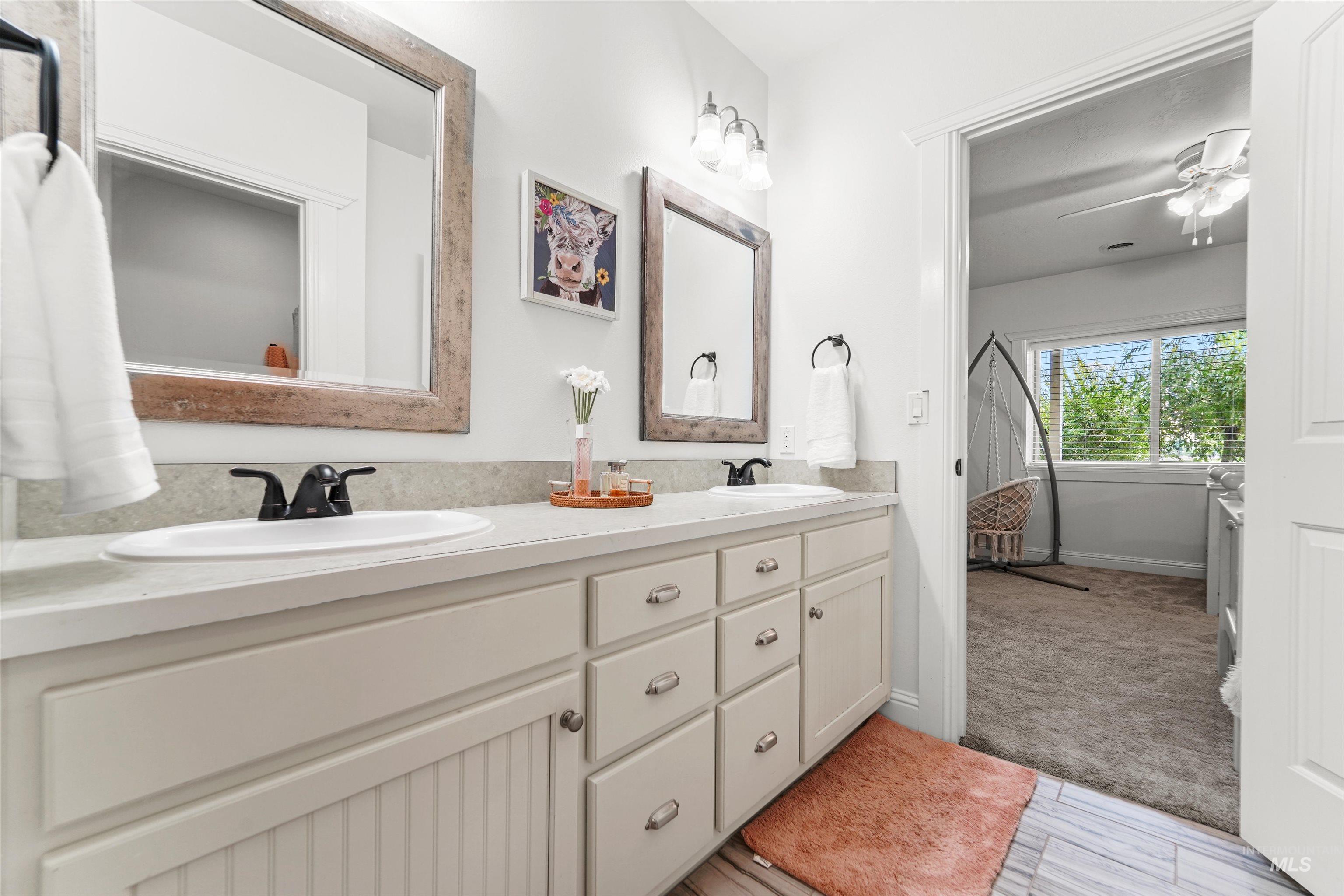 Bathroom with double vanity and ceiling fan