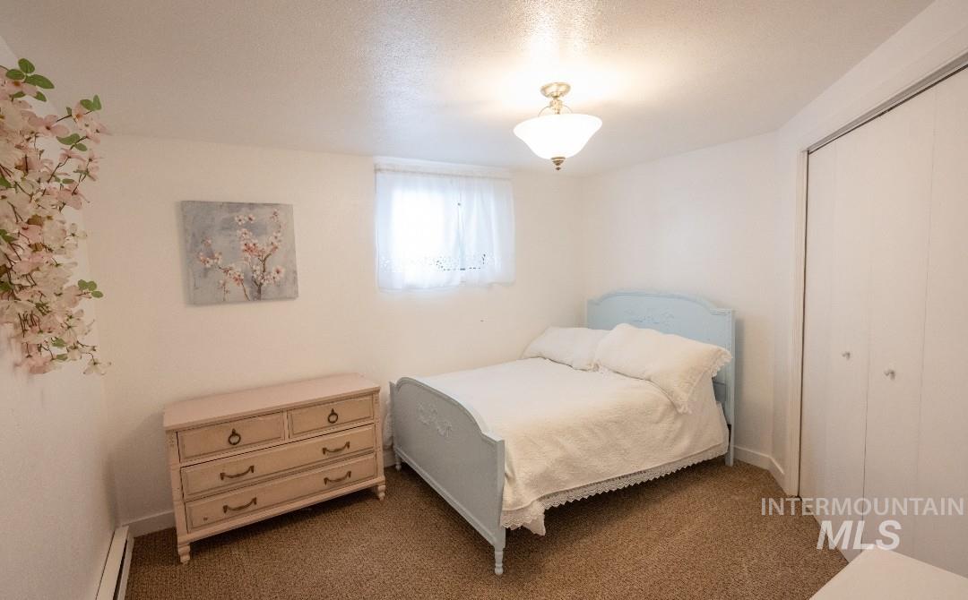 Carpeted bedroom featuring a closet and a textured ceiling
