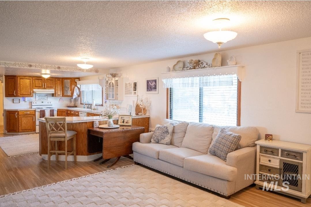 Living room featuring light wood-style floors and a textured ceiling