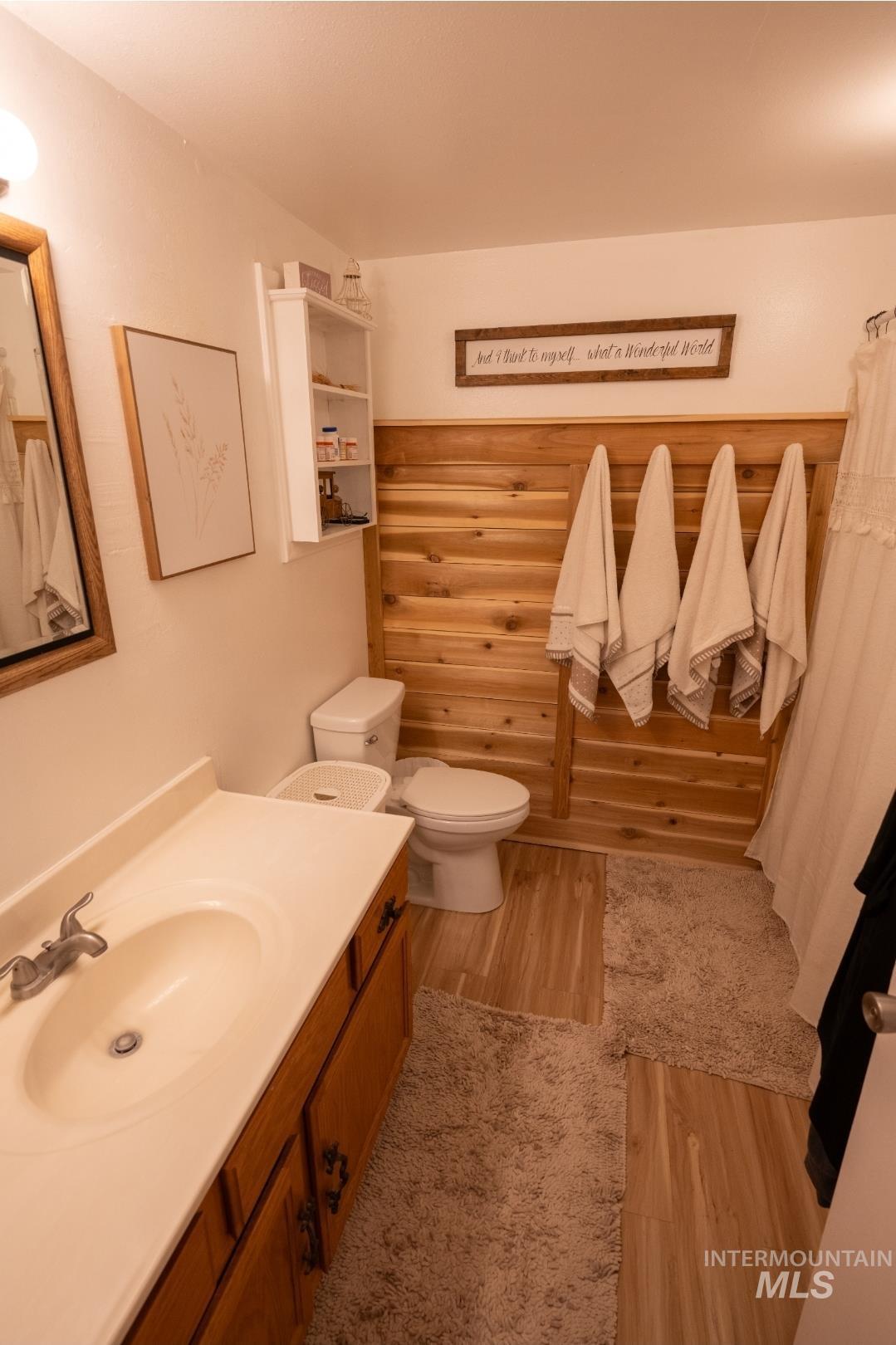 Full bath with vanity and light wood-style flooring