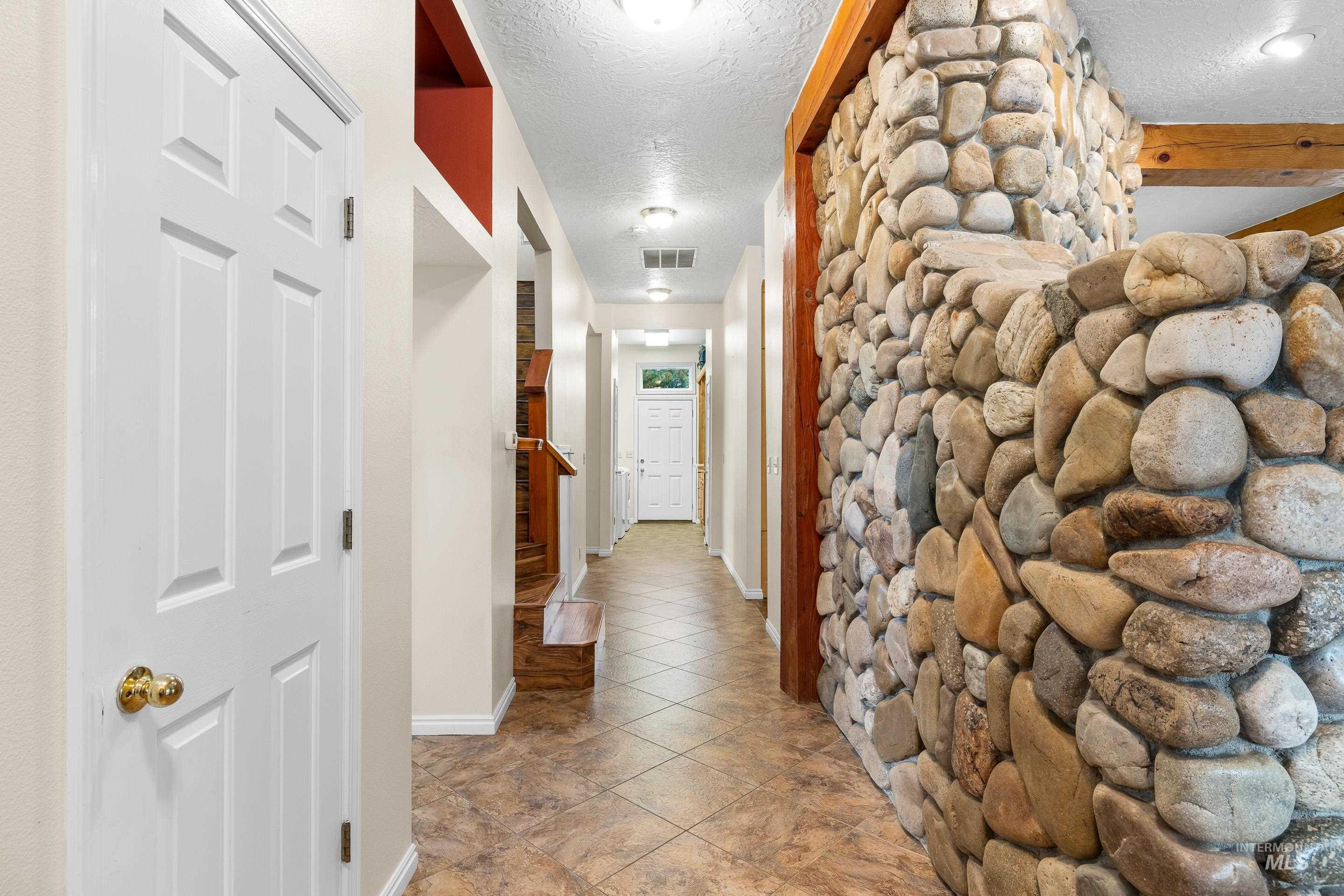 Corridor with a textured ceiling and baseboards