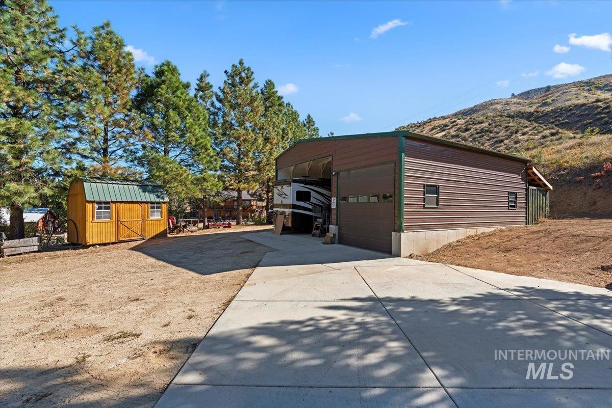 View of side of home featuring a storage shed and a mountain view
