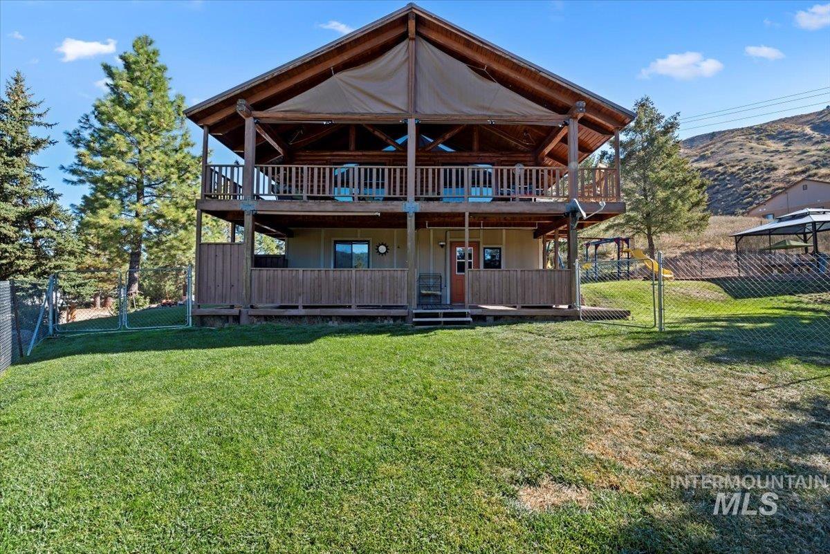 Back of house featuring a deck with mountain view and a gate