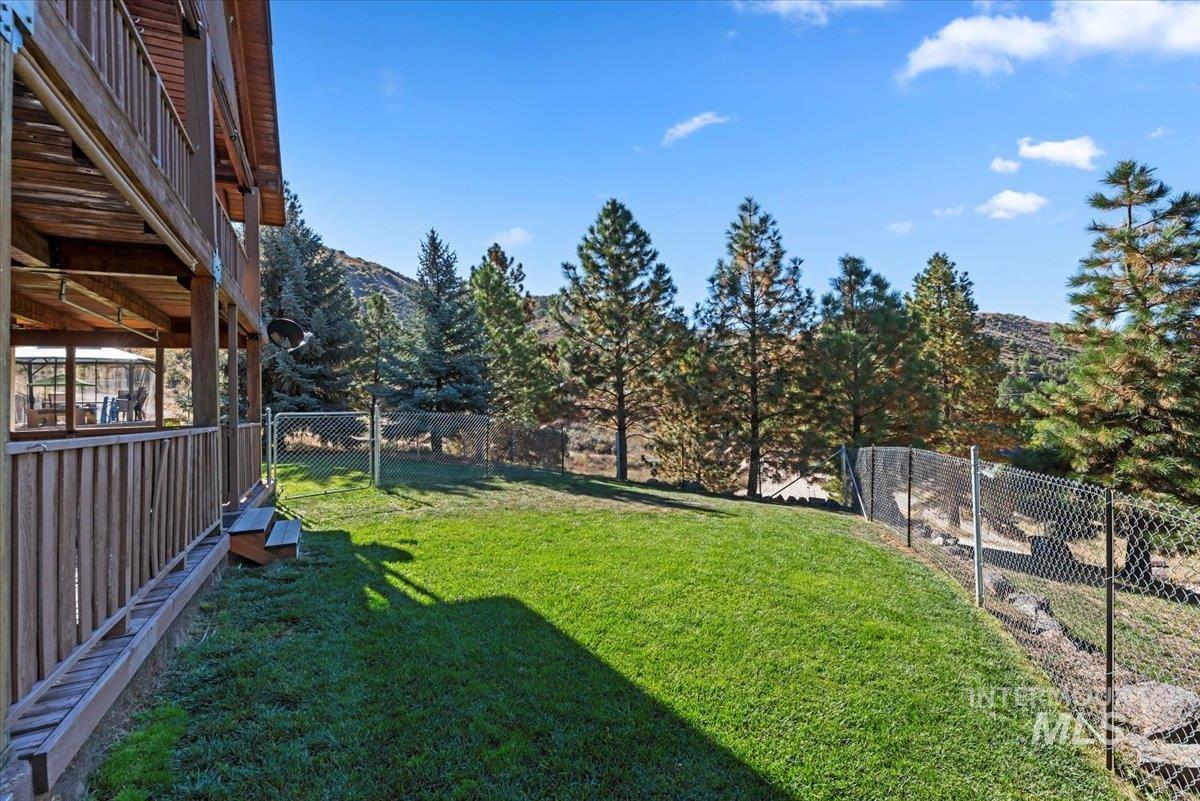 Fenced backyard with a deck with mountain view