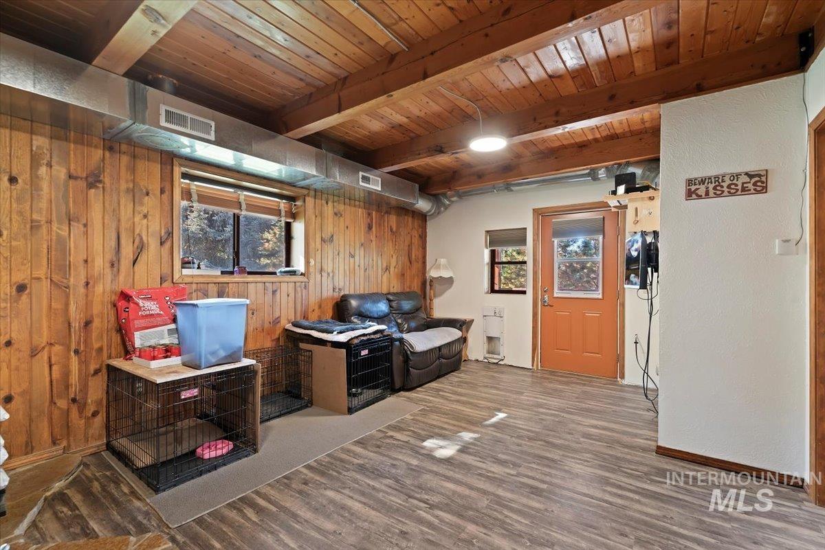 Interior space with wood walls, wood finished floors, and a wood ceiling with exposed beams