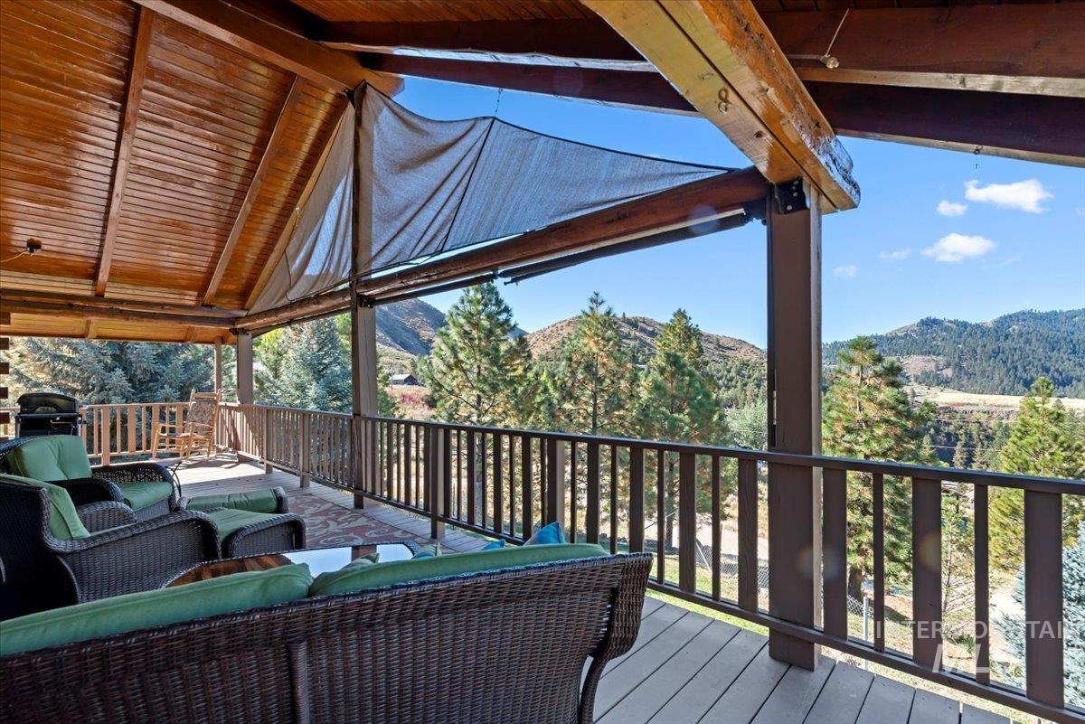 Wooden deck featuring an outdoor hangout area, a mountain view, and a grill