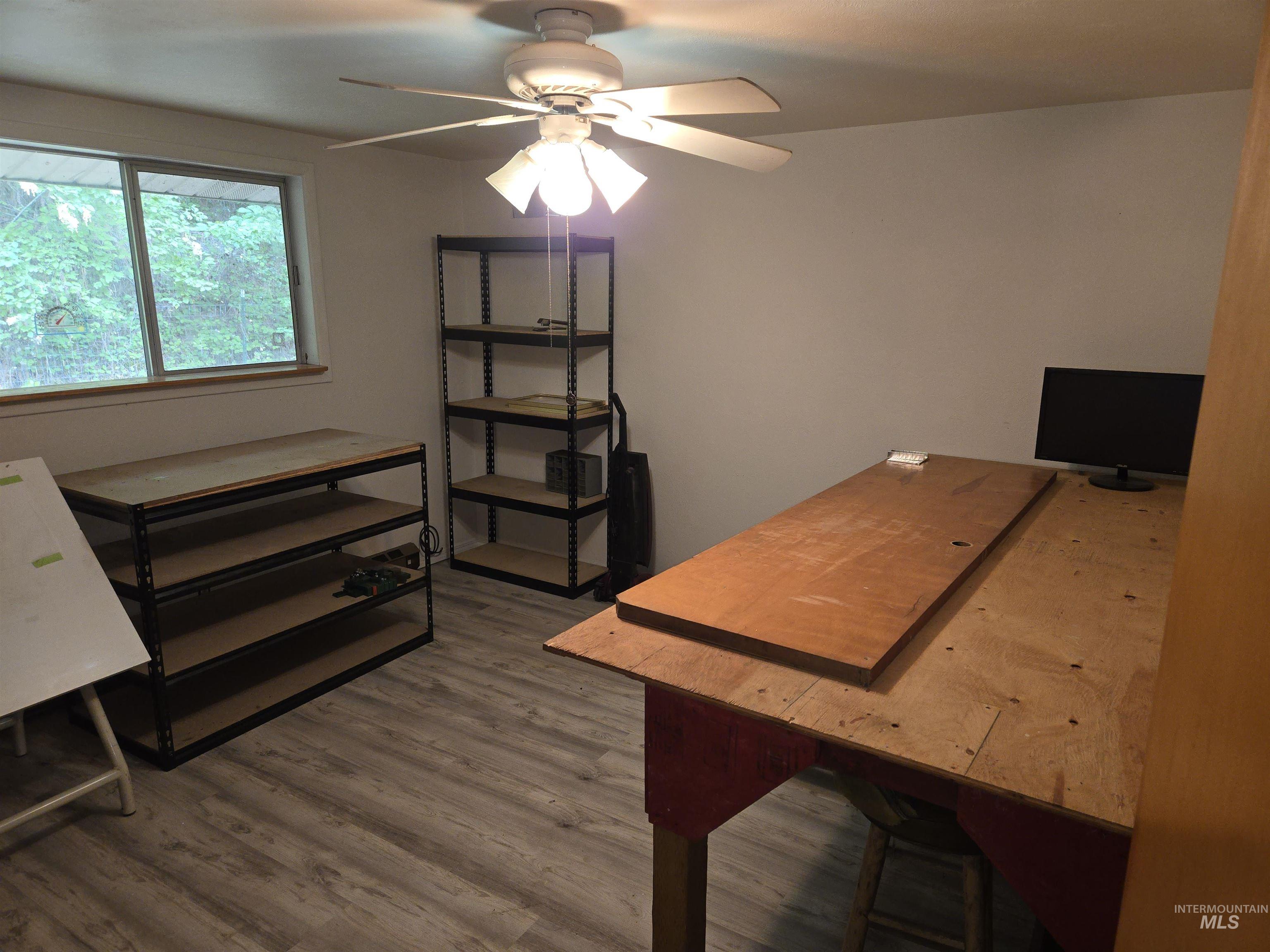 Home office with a ceiling fan and wood finished floors