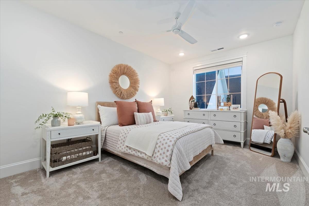 Carpeted bedroom featuring ceiling fan and recessed lighting