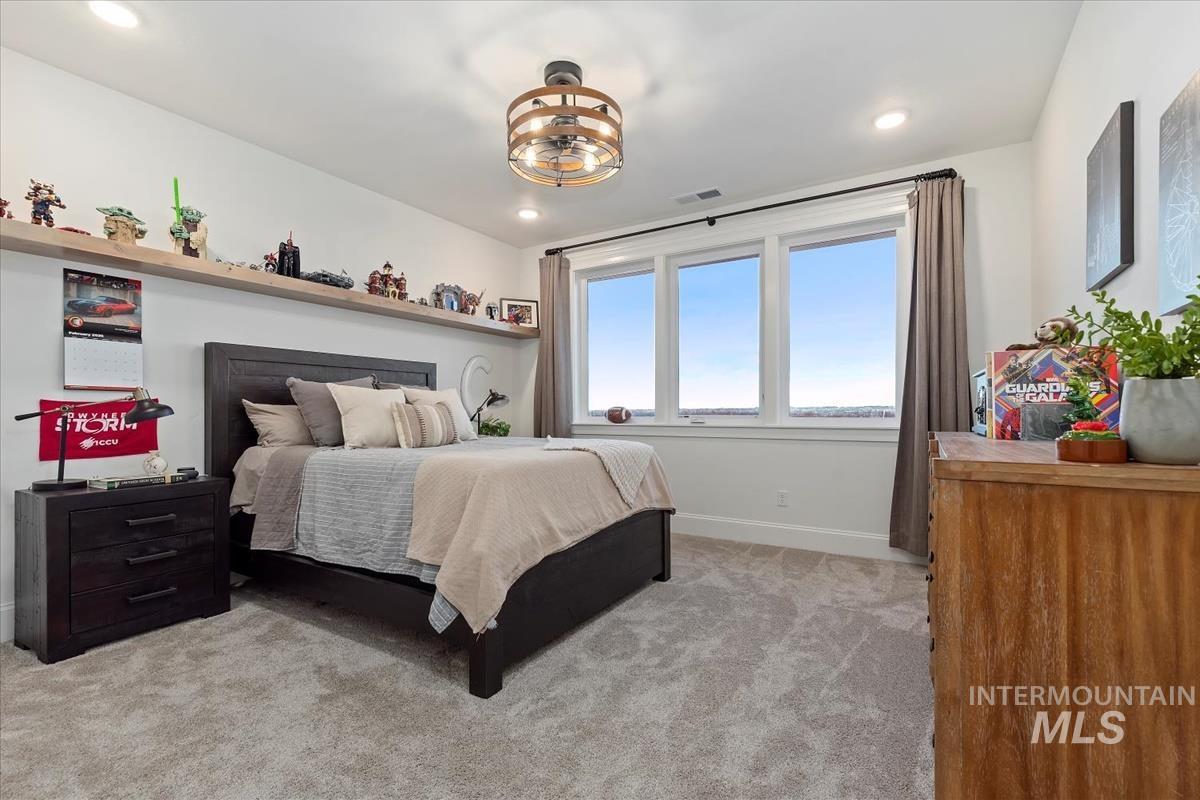 Bedroom with light colored carpet and baseboards
