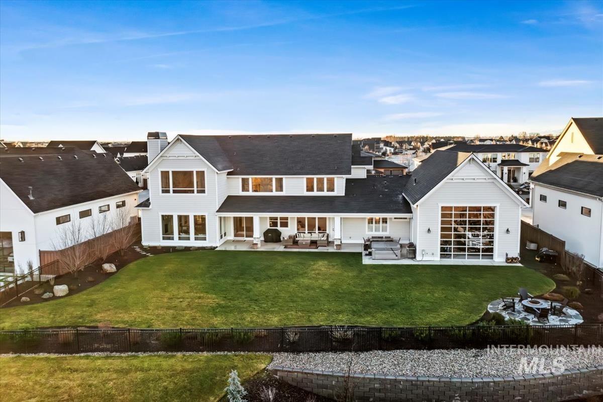 Back of property with a fenced backyard, a patio area, a chimney, and a residential view