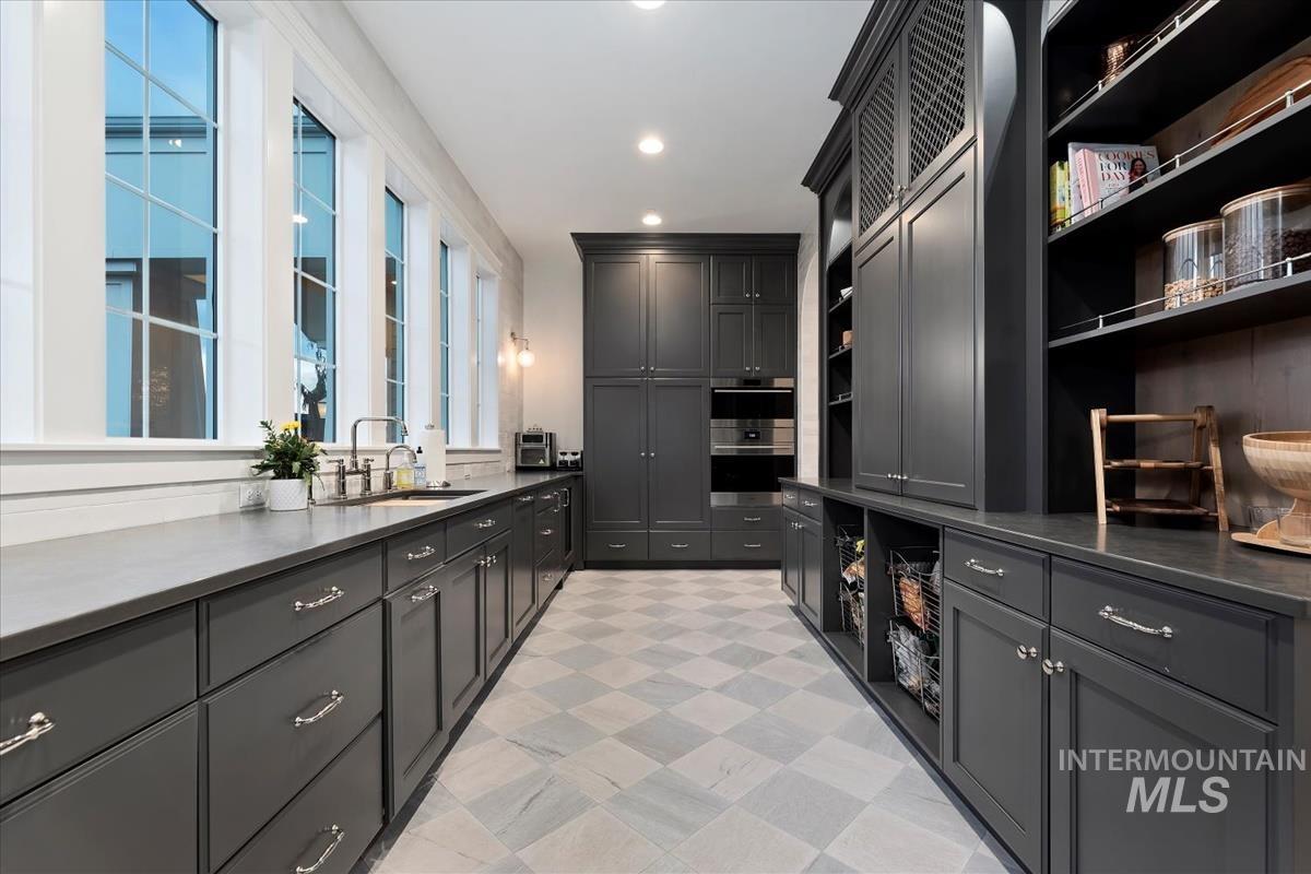 Laundry area with light flooring and recessed lighting