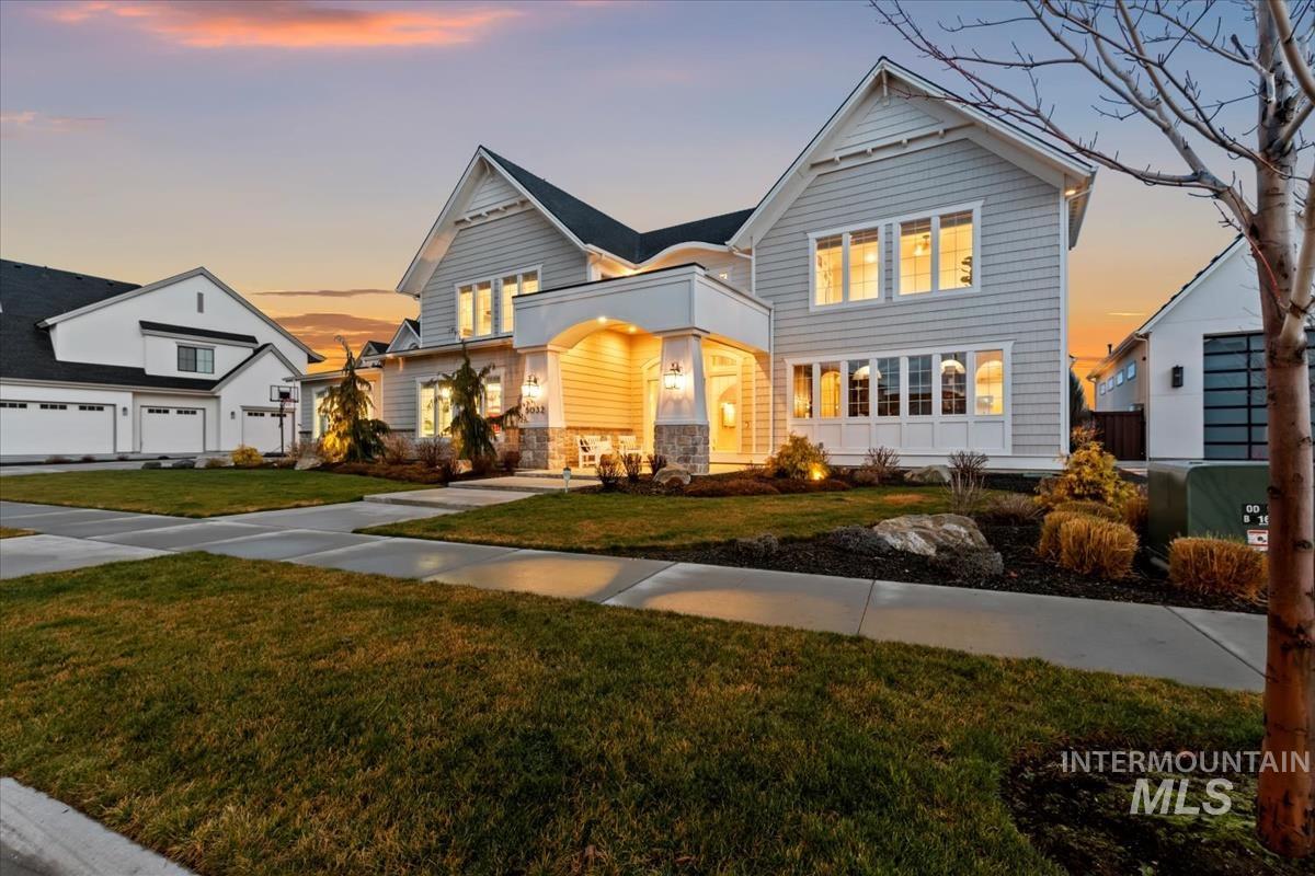 View of front of house with stone siding and a yard