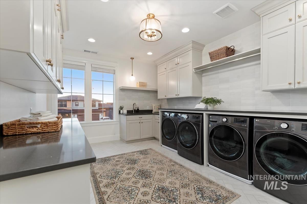 Laundry area with washer and dryer, cabinet space, and recessed lighting