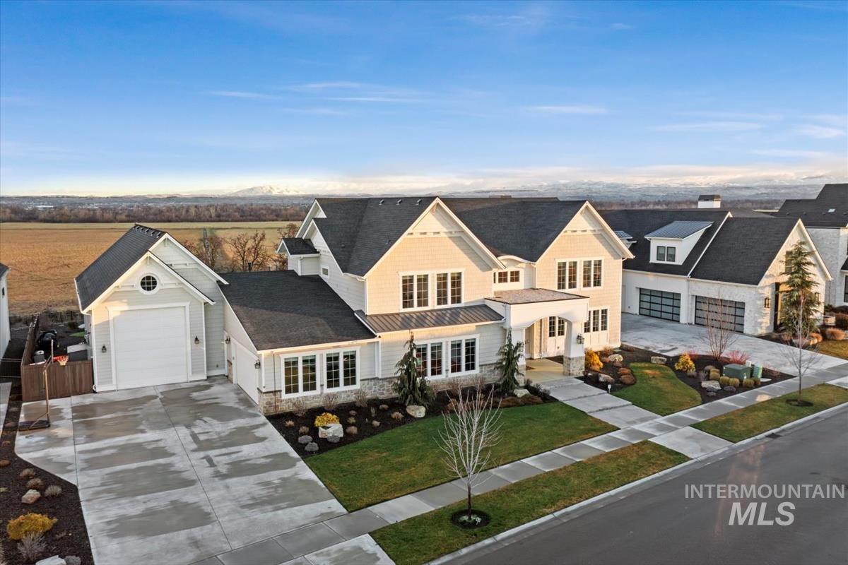 View of front facade with concrete driveway, an attached garage, stone siding, covered porch, and a front lawn