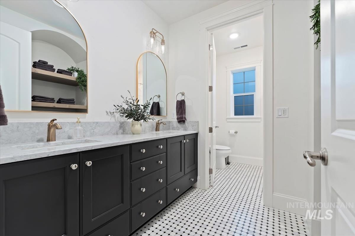 Bathroom featuring double vanity and toilet