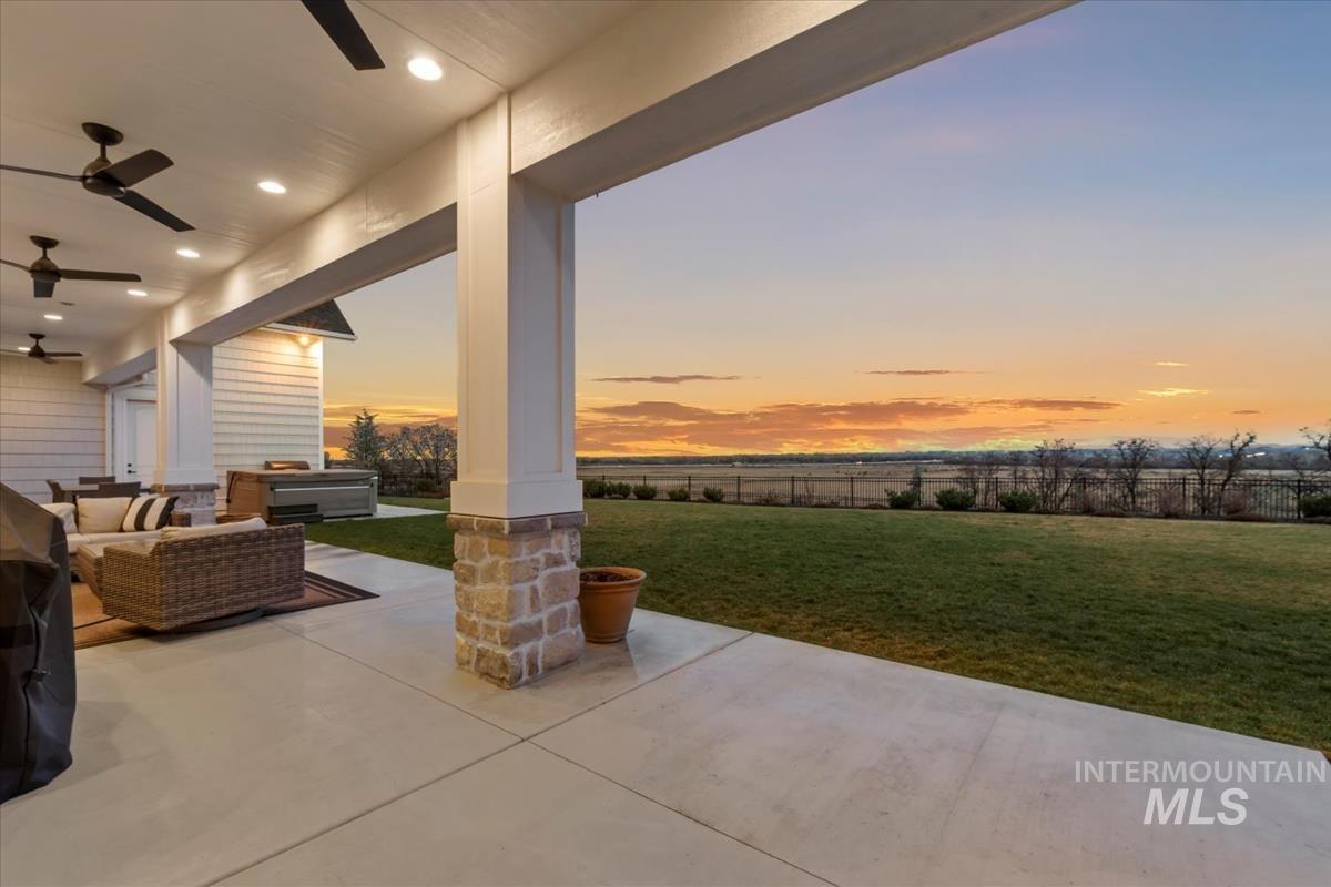 Patio terrace at dusk with ceiling fan, a patio, outdoor seating, and a fenced backyard