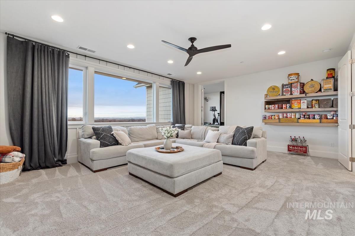 Living room featuring a ceiling fan, light colored carpet, and recessed lighting
