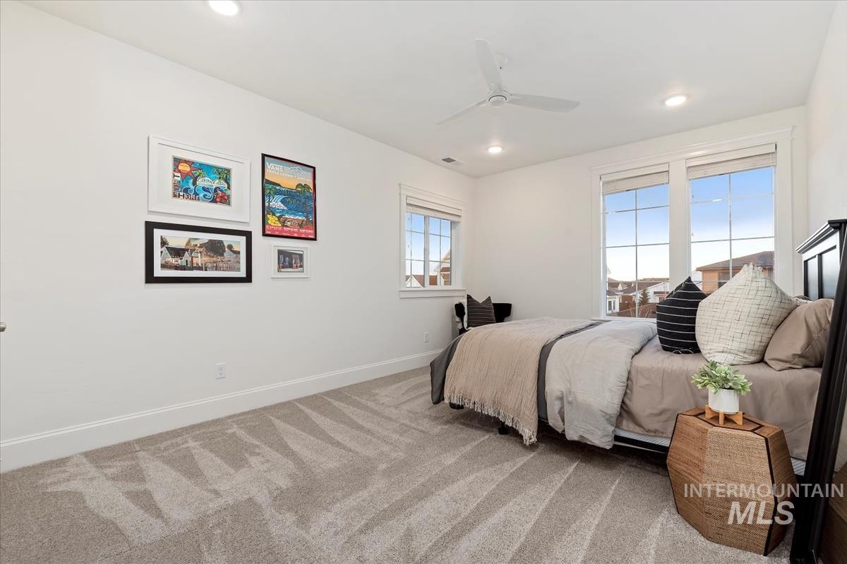 Carpeted bedroom featuring a ceiling fan and recessed lighting