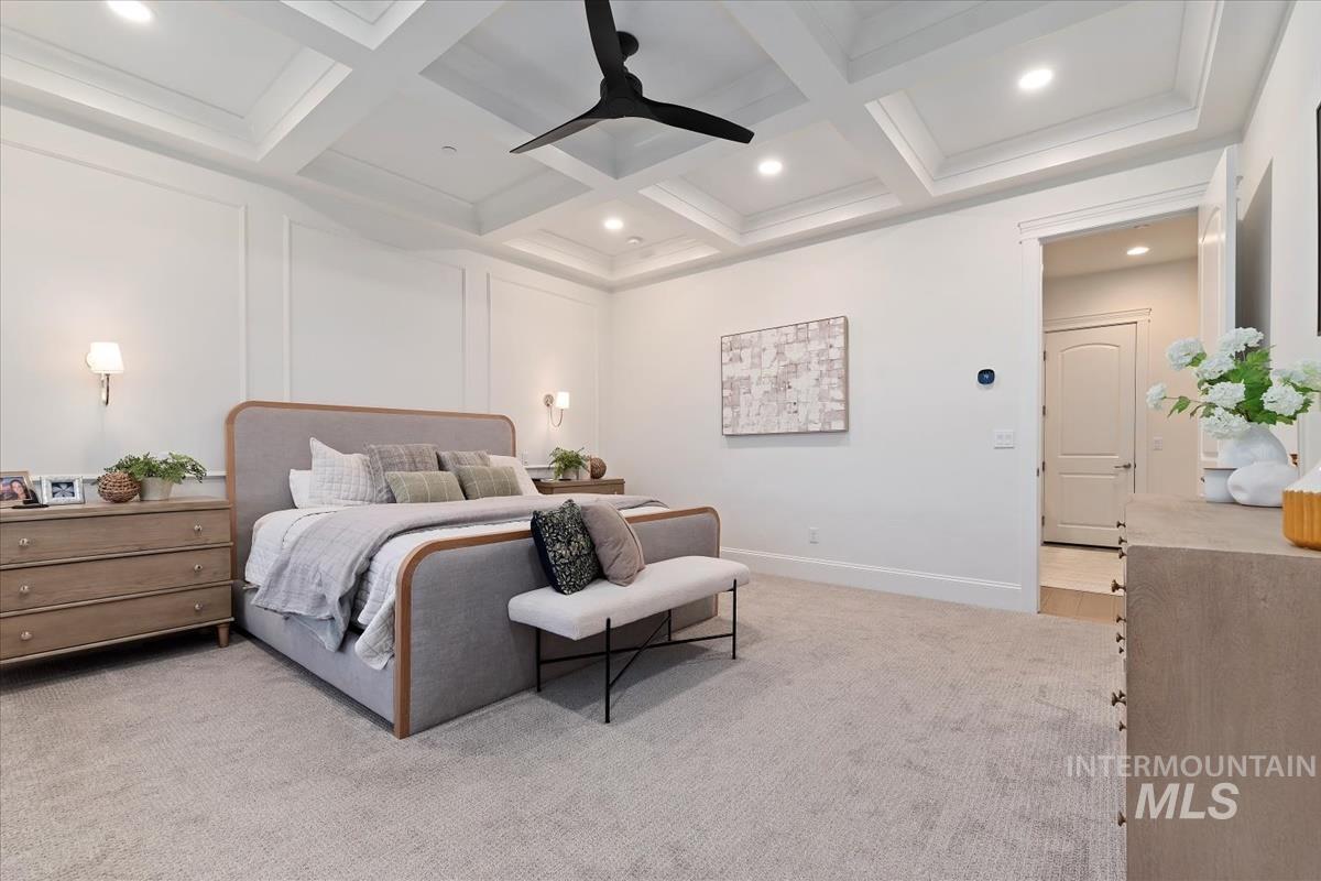Bedroom featuring light colored carpet, coffered ceiling, recessed lighting, ceiling fan, and a decorative wall