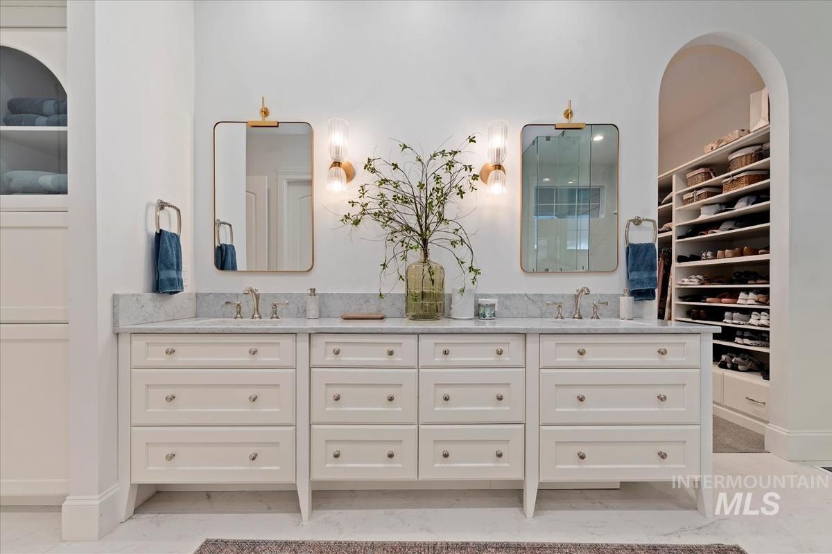 Bathroom featuring a walk in closet and double vanity