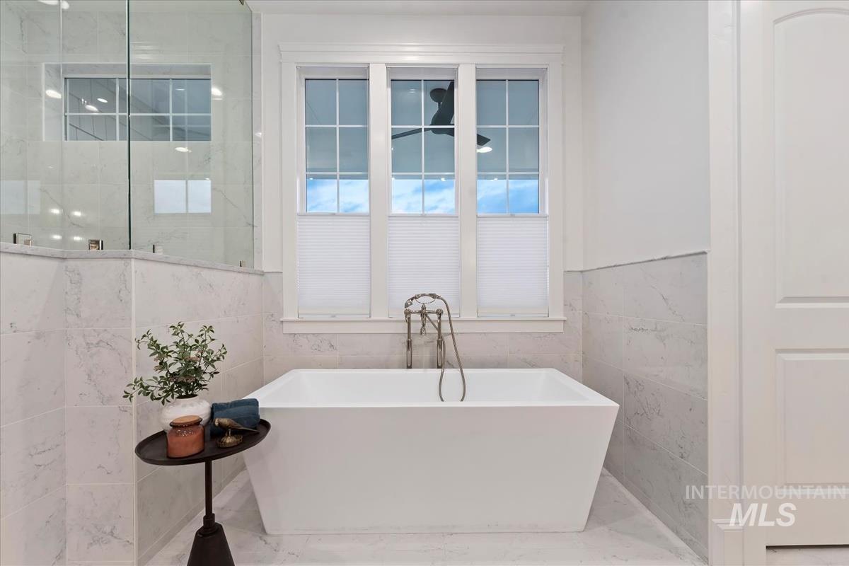 Full bath with a freestanding tub and tile walls