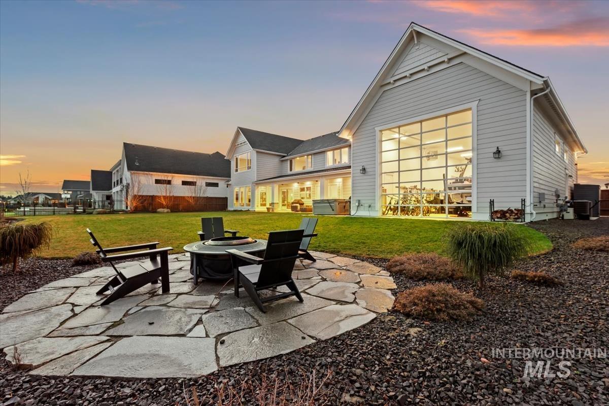 Back of house at dusk featuring a patio and an outdoor fire pit
