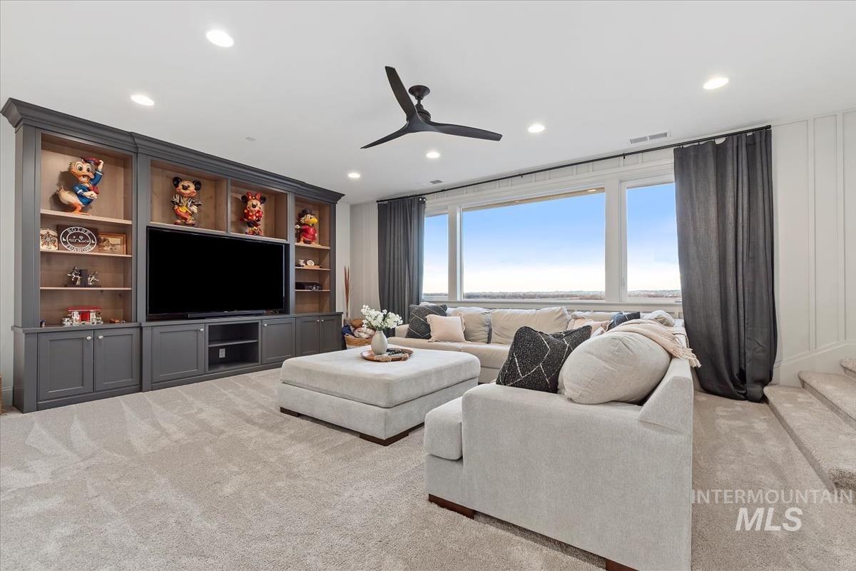 Carpeted living room featuring a ceiling fan and recessed lighting
